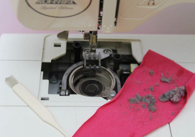 Sewing machine being cleaned and oiled during routine maintenance